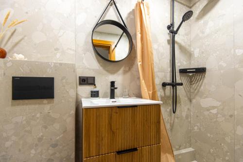 a bathroom with a sink and a mirror at Laukdvaris in Laukžemė