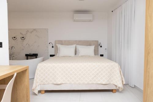 a white bedroom with a large bed with white sheets at Apartments ANA Karlobag in Karlobag