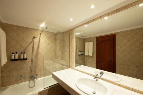 a bathroom with a sink and a shower at Mitsis La Vita in Rhodes Town