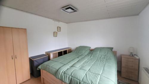 a bedroom with a bed with a green comforter at Ferienwohnung bei Stettens in Bad Neuenahr-Ahrweiler