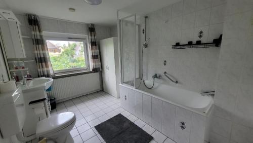 a bathroom with a tub and a toilet and a sink at Ferienwohnung bei Stettens in Bad Neuenahr-Ahrweiler