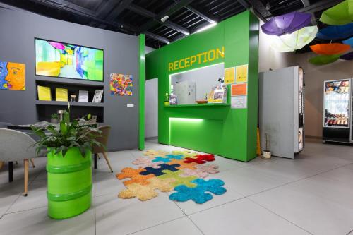 a reception area with a green wall and a rug at Green Cube Capsule Hostel in Sofia