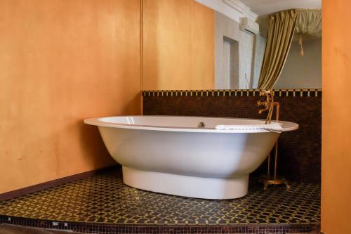 a white bath tub in a bathroom with a mirror at Sosnovel in Voropayev