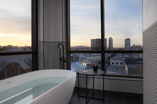 a bathroom with a tub and a view of a city at The Alva Hotel Brisbane, Vignette Collection by IHG in Brisbane