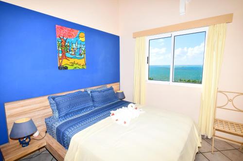 a blue bedroom with a bed and a window at THE BAY in Trou d'Eau Douce