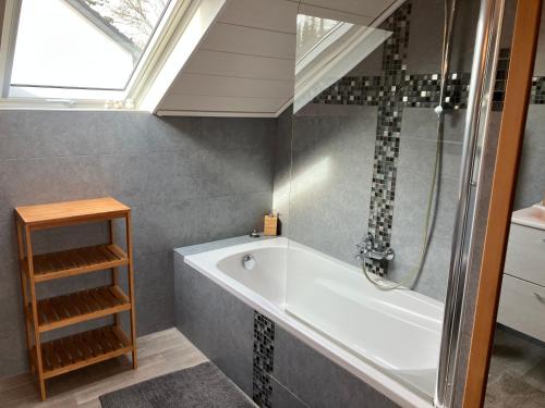 a bathroom with a bath tub and a window at Villa Angela, appartement 3 chambres in Ovifat
