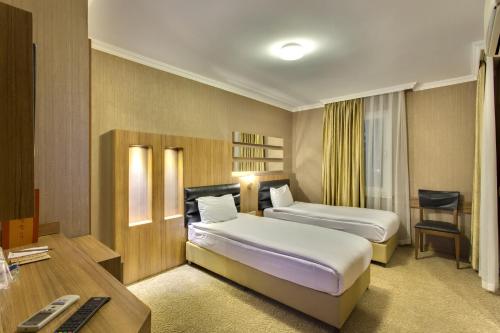 ein Hotelzimmer mit zwei Betten und einem Schreibtisch in der Unterkunft Antroyal Hotel in Antalya