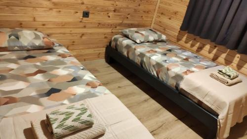 two beds in a room with wooden walls at Şimal Bungalov in Samsun