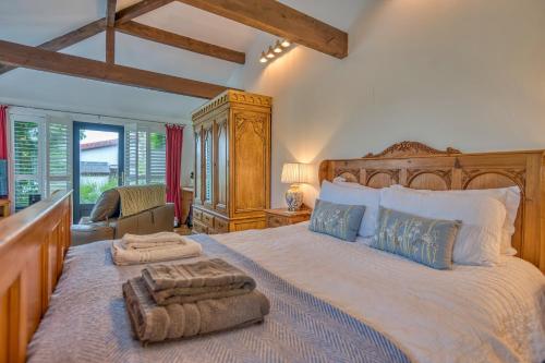 a bedroom with a large bed with a wooden headboard at Finest Retreats - Jabajak Vineyard in Whitland