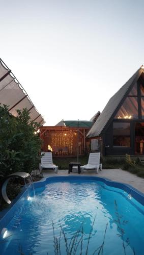 a swimming pool with two chairs and a house at Şimal Bungalov in Samsun
