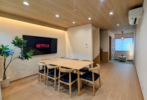 a dining room with a table and chairs and a tv at Dream Stays HIKARI in Osaka