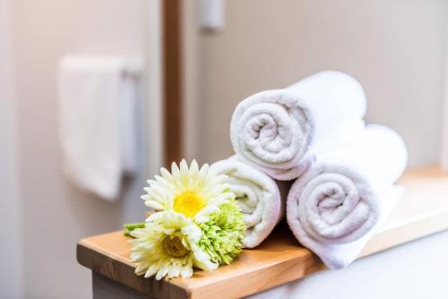 a pile of towels and flowers on a bathroom counter at Gran kodachi in Fujikawaguchiko