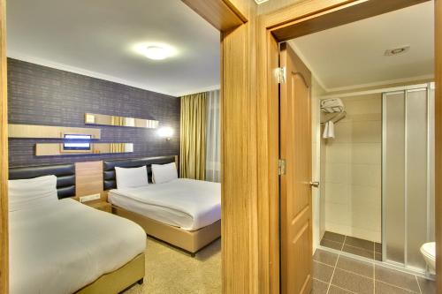 ein Hotelzimmer mit zwei Betten und einem Badezimmer in der Unterkunft Antroyal Hotel in Antalya