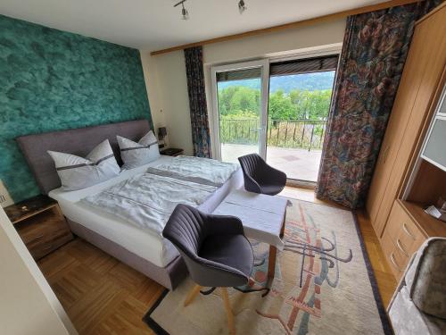 a bedroom with a bed and two chairs and a window at Haus Rattenböck in St. Wolfgang