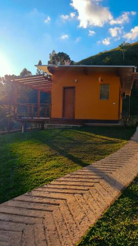 a house with a brick walkway in front of it at Chalé Topázio Gonçalves in Gonçalves