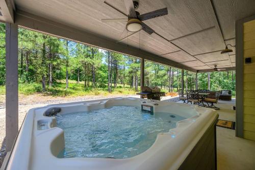 a hot tub in a house with a large window at Private Escape| Hot tub| Fire Pit| Trail Access in Broken Bow