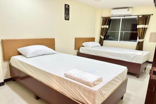 a room with two beds and a window at Baan at Khaosan Hotel in Bangkok
