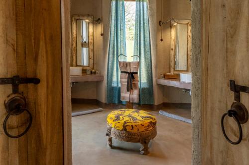 a bathroom with a ottoman in the middle of a room at Onguma The Fort in Namutoni Gate