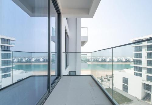 a large glass balcony with a view of the water at Stunning Oceanfront Studio Stay - Blue Bay Walk Pool & Gym in Sharjah