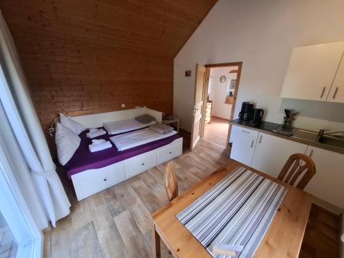 a bedroom with a bed and a table and a kitchen at Mitteltalhof in Kaufungen
