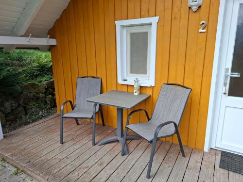 a table and chairs on a porch with a window at Mitteltalhof in Kaufungen
