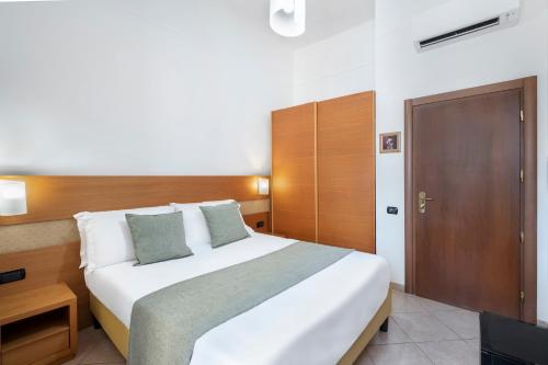 a bedroom with a large white bed and a television at Hotel Moscatello in Rome