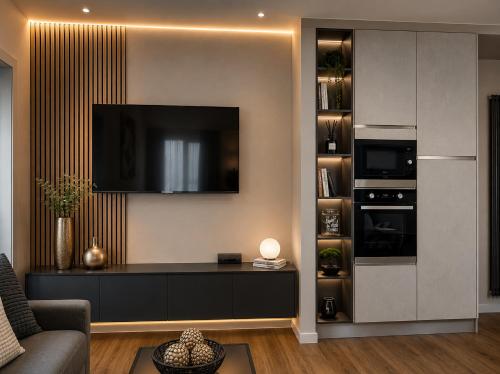 a living room with a tv on a wall at The Captain's Apartments Marina - next to Verbella - Leonardo Academy, MXP in Sesto Calende