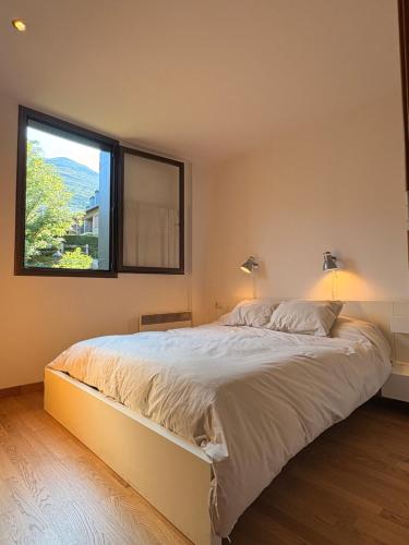 a bedroom with a large bed with a window at Con encanto, buena ubicación, confort y parking - Aüt 2 in Pla de l'Ermita