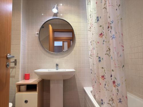 a bathroom with a sink and a mirror and a shower curtain at Con encanto, buena ubicación, confort y parking - Aüt 2 in Pla de l'Ermita