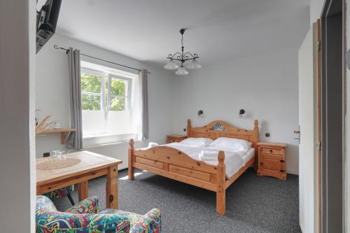 a bedroom with a bed and a table and a chair at Penzion Janoštík in Rožnov pod Radhoštěm