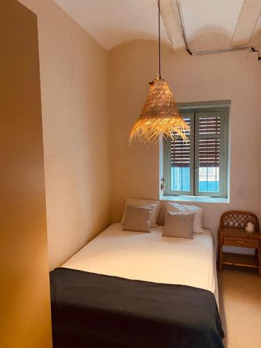 a bedroom with a bed with a window and a chandelier at Casa Purissima in Ontinyent