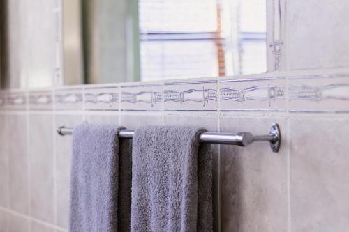 a bathroom with two towels hanging on a towel rack at Jakaranda Cabin - Self Catering Apartment in Secunda