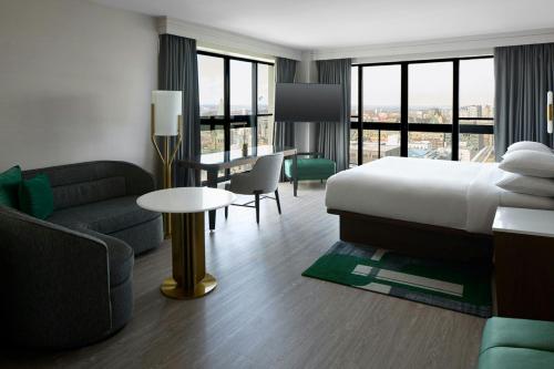 ein Hotelzimmer mit einem Bett, einer Couch und einem Tisch in der Unterkunft Ottawa Marriott Hotel in Ottawa