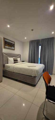 a bedroom with a large bed and a chair at The Loxwood Premier Suites in Accra