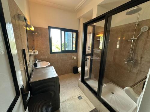 a bathroom with a shower and a sink at Bonapriso in Douala