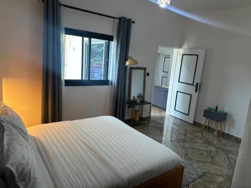 a bedroom with a bed and a window and a mirror at Bonapriso in Douala