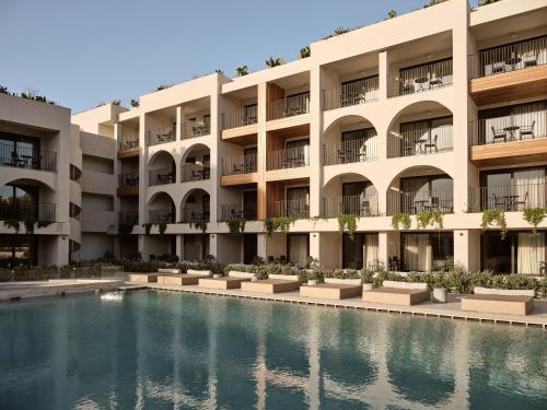 an apartment building with a pool in front of it at Planos Deluxe in Zakynthos
