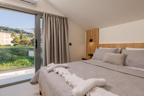a bedroom with a bed and a large window at Andelice Zante in Argassi