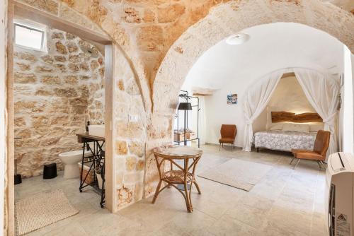an archway in a bedroom with a bed and a table at Trullo Sobba Llera by BarbarHouse in San Michele Salentino