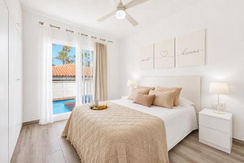 a white bedroom with a bed and a window at CHALET 273 con PISCINA PRIVADA in Callao Salvaje