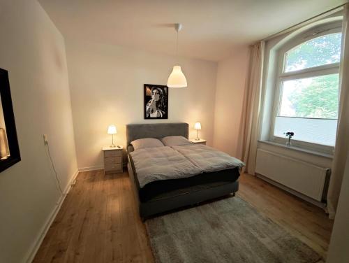 a bedroom with a bed and a large window at Tolle Moderne Altbau Wohnung in Hohenlockstedt