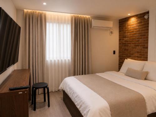 a hotel room with a large bed and a window at Stay PAUSE in Bucheon