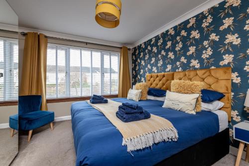 a bedroom with a blue bed and a blue chair at Driftwood - Crail in Crail