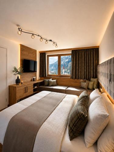a bedroom with a large bed and a couch at Bergdiamant Nauders in Nauders