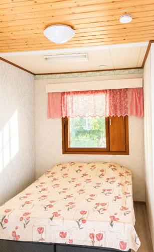 a bed in a small room with a window at Lakeuden Sydän in Kauhajoki