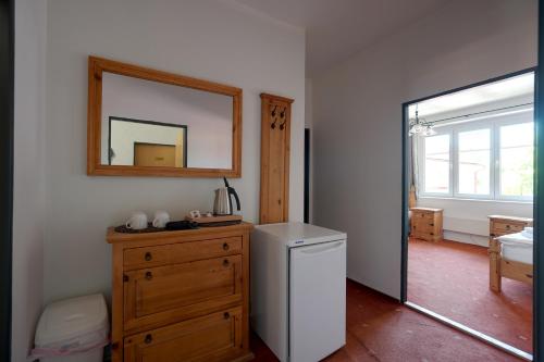 a bathroom with a wooden dresser and a mirror at Penzion Janoštík in Rožnov pod Radhoštěm