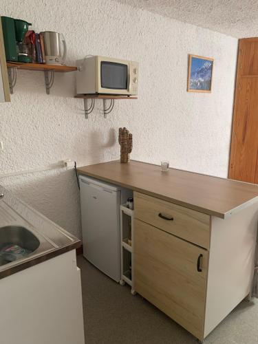 a kitchen with a counter and a microwave on the wall at Studio Cosy pied des pistes in Saint-Léger-les-Mélèzes