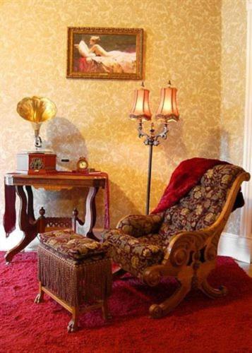 a living room with a chair and a table at Alexander Mansion Bed and Breakfast in Winona