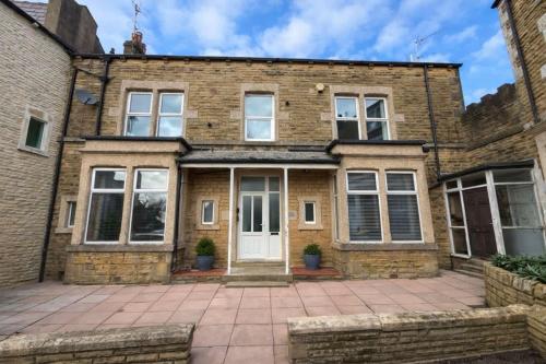 an old brick house with a white door at New Top Floor Large 1- Bed Flat in Morecambe