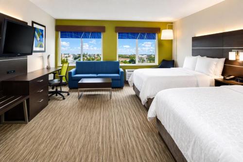 a hotel room with two beds and a flat screen tv at Holiday Inn Express Wixom by IHG in Wixom